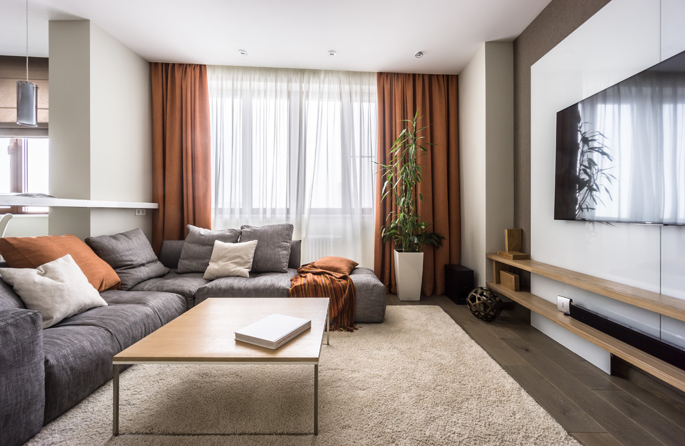 Photo of a mid-sized contemporary open concept living room in Moscow with white walls, medium hardwood floors, no fireplace, a wall-mounted tv and brown floor.