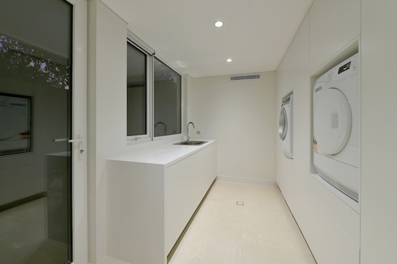 Photo of a contemporary laundry room in Perth with white walls and a side-by-side washer and dryer.