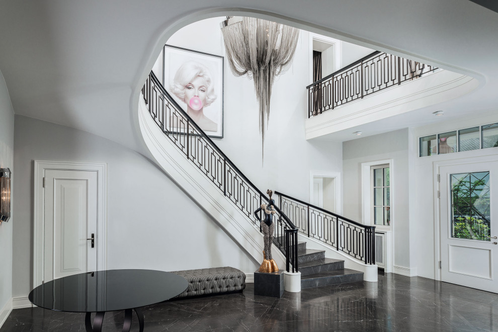 Свежая идея для дизайна: большая изогнутая лестница в классическом стиле с мраморными ступенями, подступенками из мрамора и металлическими перилами - отличное фото интерьера