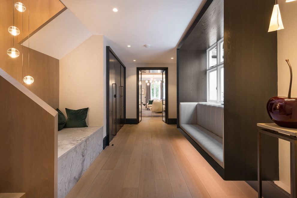 Inspiration for a contemporary hallway in London with white walls and light hardwood floors.