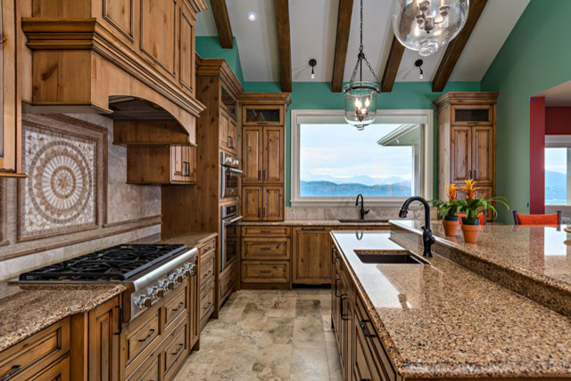 Inspiration for a large transitional u-shaped travertine floor eat-in kitchen remodel in Vancouver with an undermount sink, raised-panel cabinets, medium tone wood cabinets, granite countertops, brown backsplash, stone tile backsplash, paneled appliances and an island