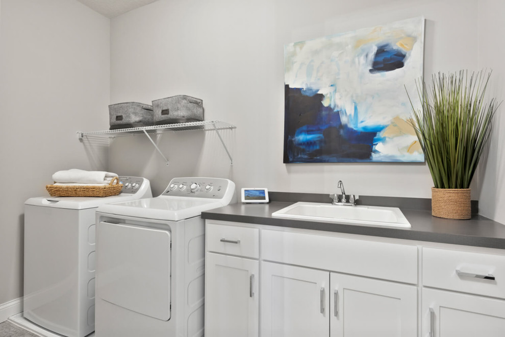 Inspiration for a classic single-wall separated utility room in Minneapolis with a single-bowl sink, shaker cabinets, white cabinets, grey walls, vinyl flooring, a side by side washer and dryer, grey floors and grey worktops.