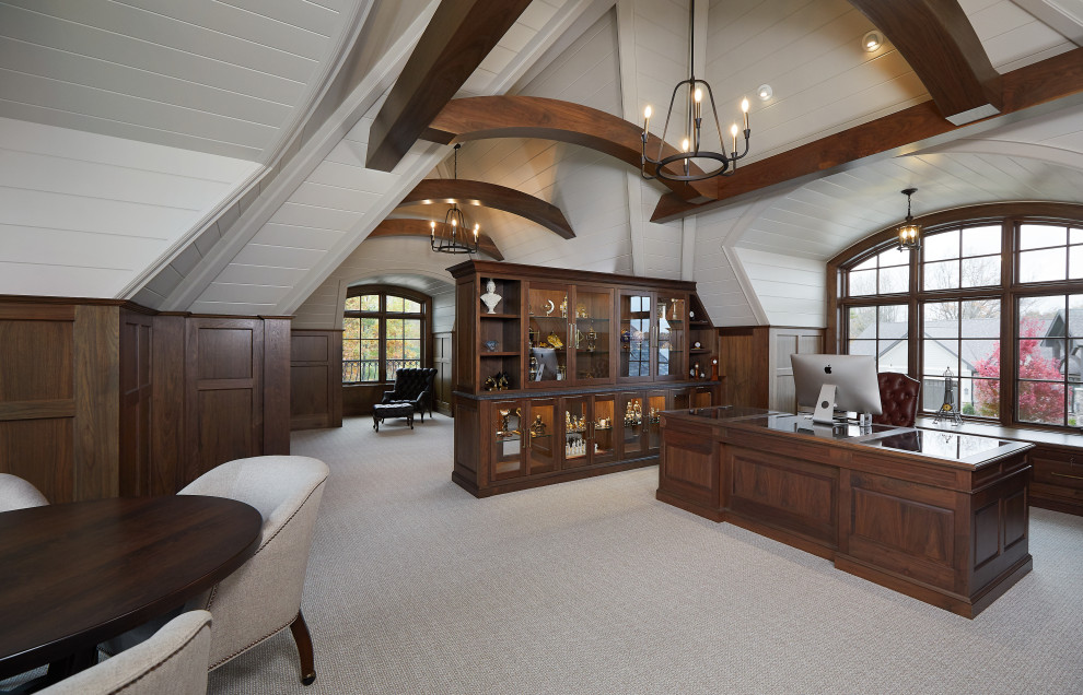 This is an example of a home office in Grand Rapids with white walls, carpet, a built-in desk, beige floors, a vaulted ceiling, tongue and groove walls and feature lighting.