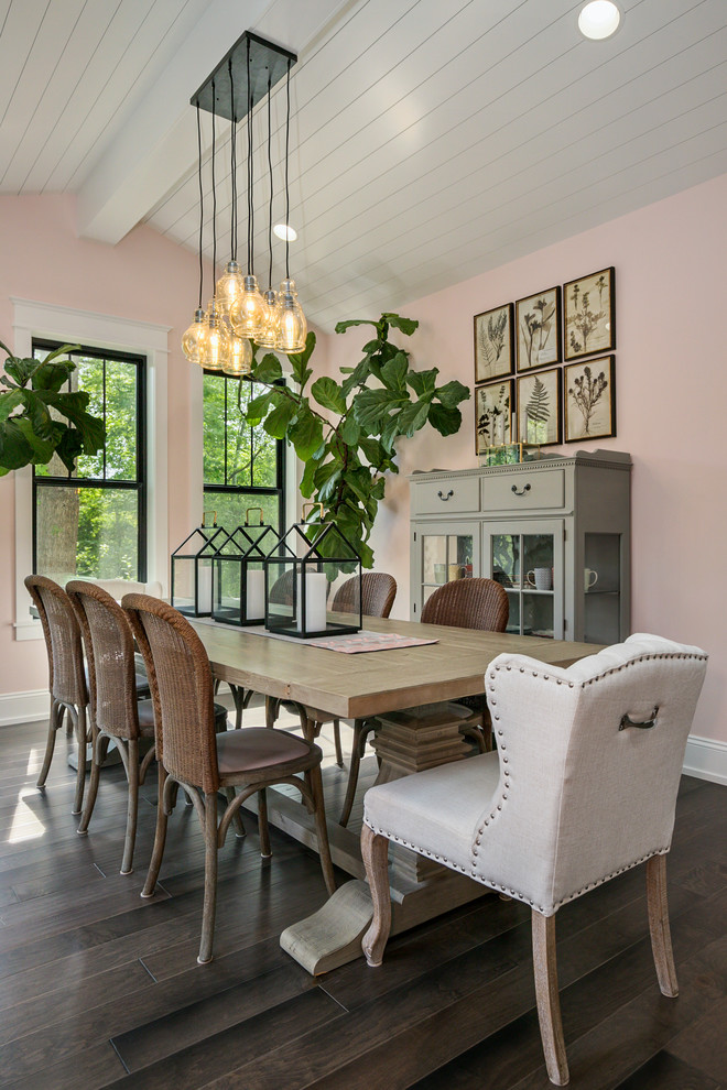Country separate dining room in Grand Rapids with pink walls and dark hardwood floors.