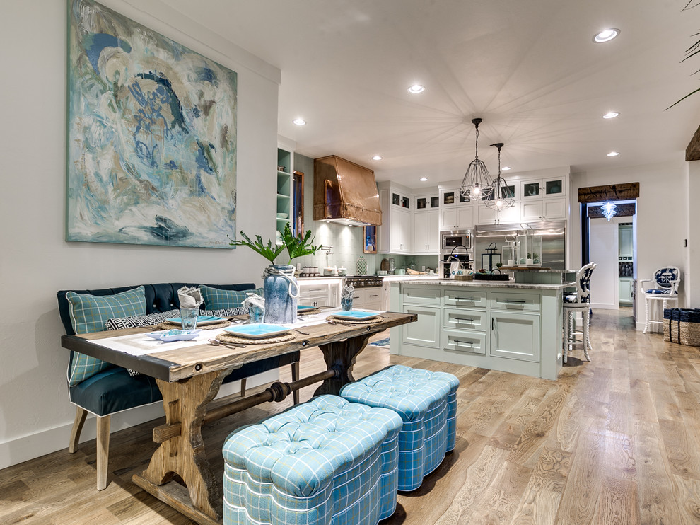 This is an example of a beach style kitchen/dining combo in Oklahoma City with white walls and light hardwood floors.