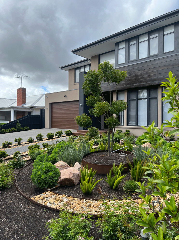 Photo of a medium sized contemporary front full sun garden for autumn with a rockery, decorative stones and a wood fence.
