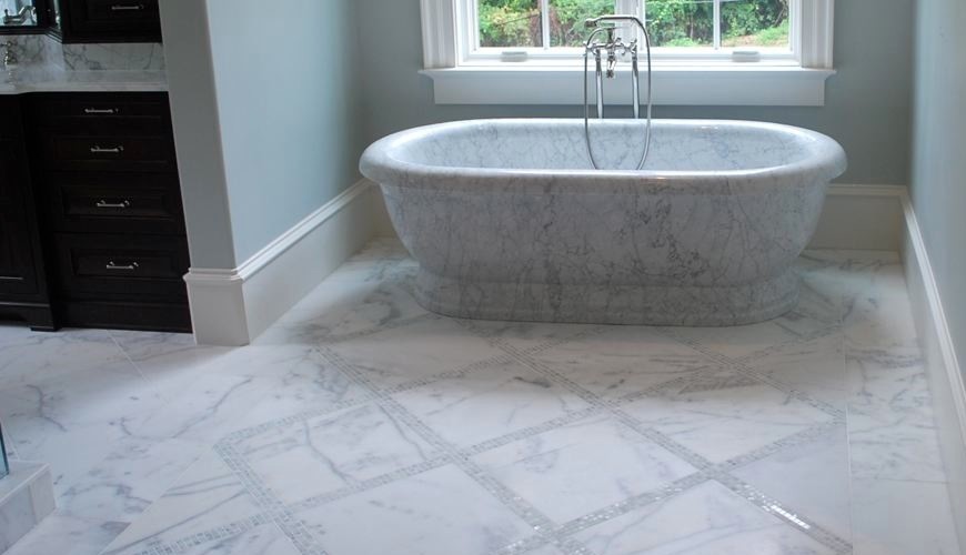 Large transitional master marble floor and white floor freestanding bathtub photo with recessed-panel cabinets, black cabinets, gray walls and marble countertops