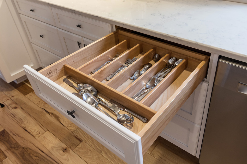 Inspiration for a large transitional u-shaped medium tone wood floor and brown floor enclosed kitchen remodel with an undermount sink, shaker cabinets, white cabinets, quartzite countertops, white backsplash, subway tile backsplash, stainless steel appliances and an island