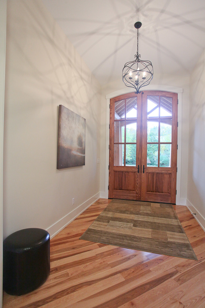 Design ideas for an arts and crafts foyer in Louisville with beige walls, light hardwood floors, a double front door and a medium wood front door.