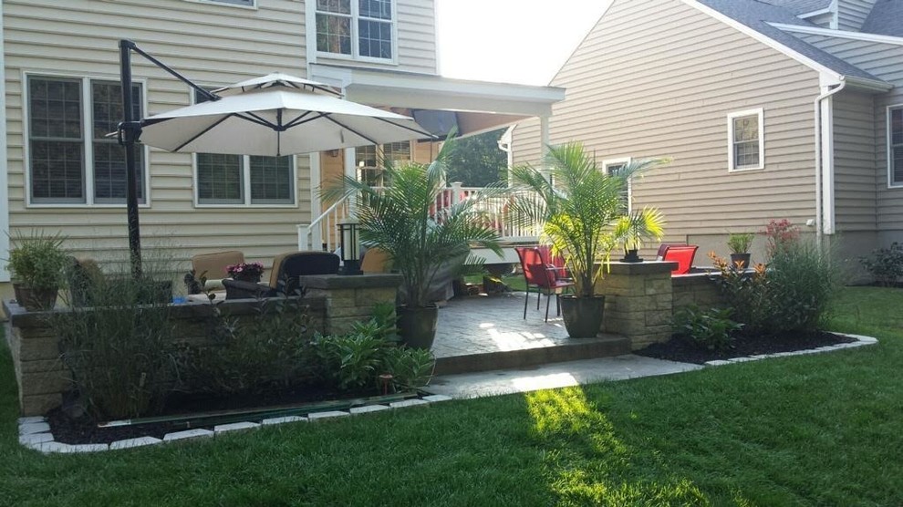 This is an example of a mid-sized mediterranean backyard partial sun garden in Other with natural stone pavers.