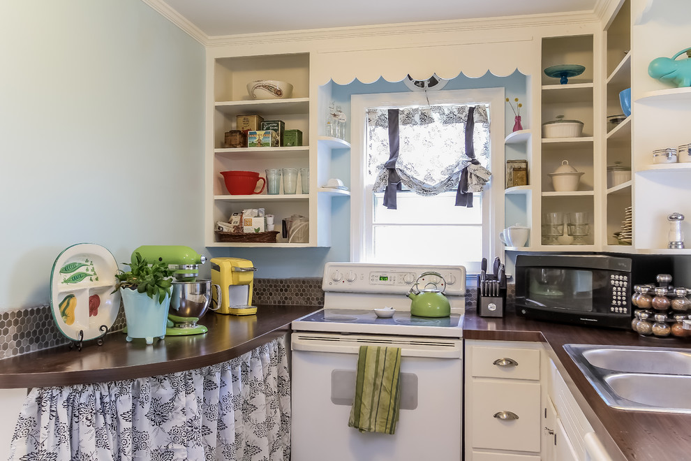 Small eclectic u-shaped separate kitchen in Grand Rapids with a drop-in sink, flat-panel cabinets, white cabinets, laminate benchtops, brown splashback, ceramic splashback, white appliances, dark hardwood floors and no island.