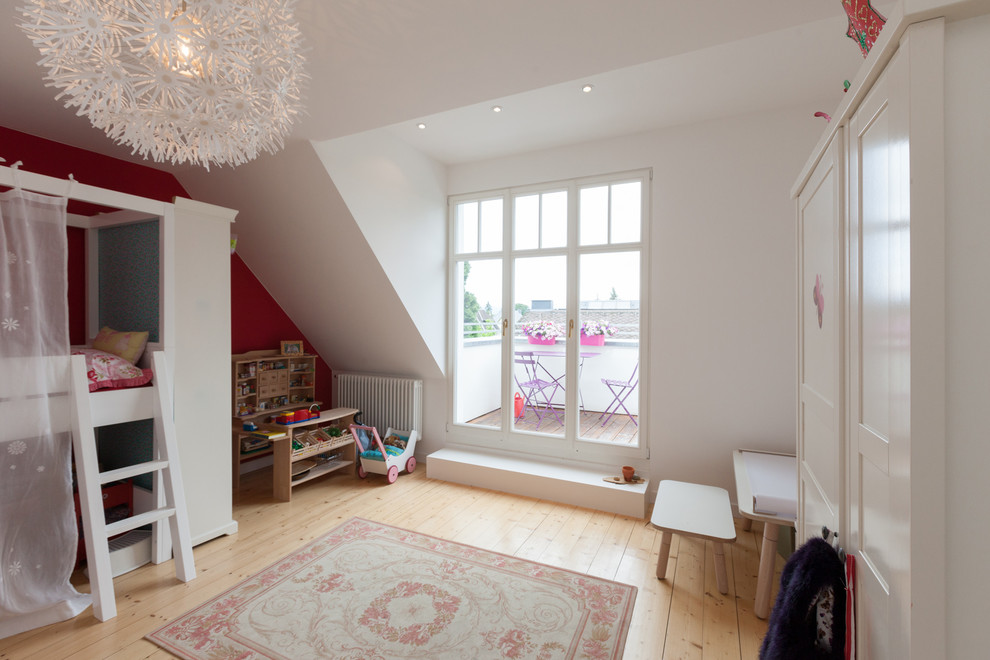 Design ideas for a mid-sized traditional kids' bedroom for kids 4-10 years old and girls in Frankfurt with light hardwood floors and multi-coloured walls.