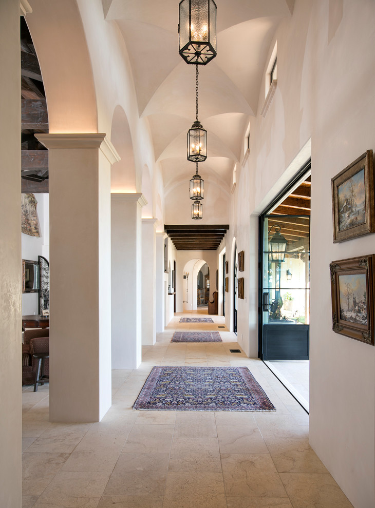 Design ideas for a mediterranean hallway in Santa Barbara with white walls and beige floor.