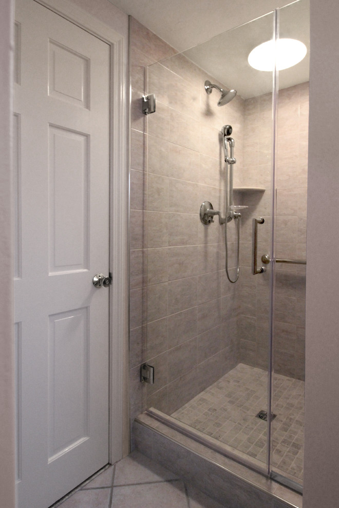 Photo of a large contemporary master bathroom in Boston with an undermount sink, flat-panel cabinets, medium wood cabinets, engineered quartz benchtops, a drop-in tub, a corner shower, a two-piece toilet, beige tile, porcelain tile, grey walls and ceramic floors.