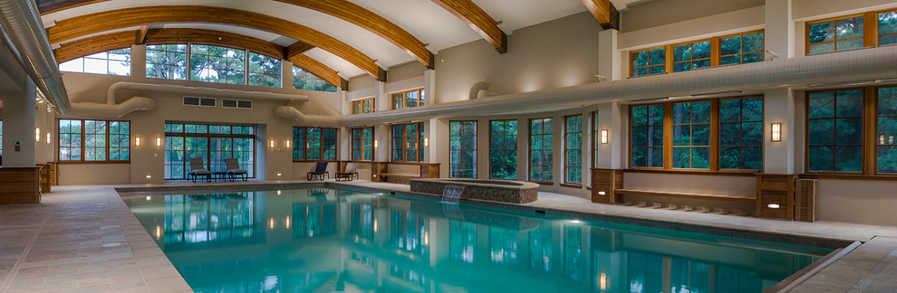 This is an example of an expansive transitional indoor rectangular pool in Baltimore with a water feature.