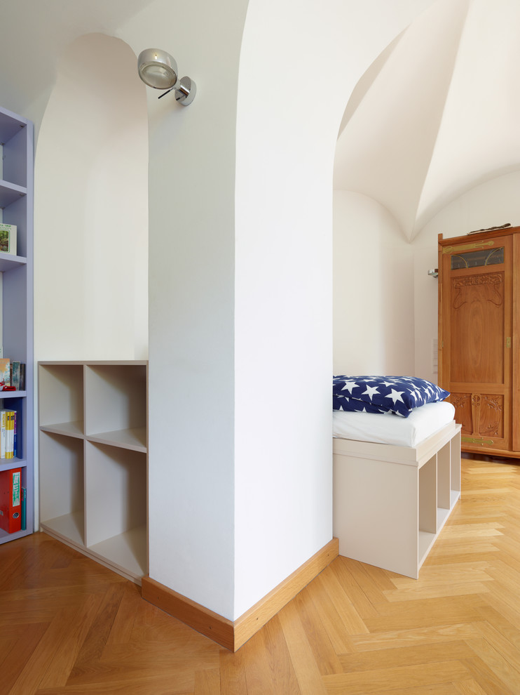 Design ideas for a mid-sized contemporary kids' room in Dresden with white walls and light hardwood floors.
