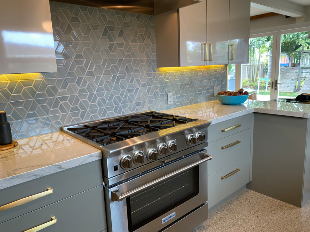 Example of a mid-sized 1960s galley terrazzo floor and multicolored floor enclosed kitchen design in San Diego with a single-bowl sink, flat-panel cabinets, gray cabinets, quartzite countertops, blue backsplash, ceramic backsplash, paneled appliances, a peninsula and white countertops