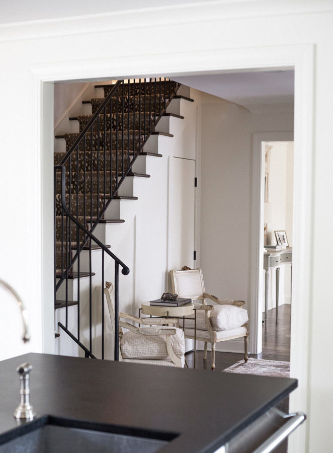 Mid-sized transitional galley dark wood floor eat-in kitchen photo with an undermount sink, shaker cabinets, white cabinets, soapstone countertops, gray backsplash, stone slab backsplash, white appliances and an island