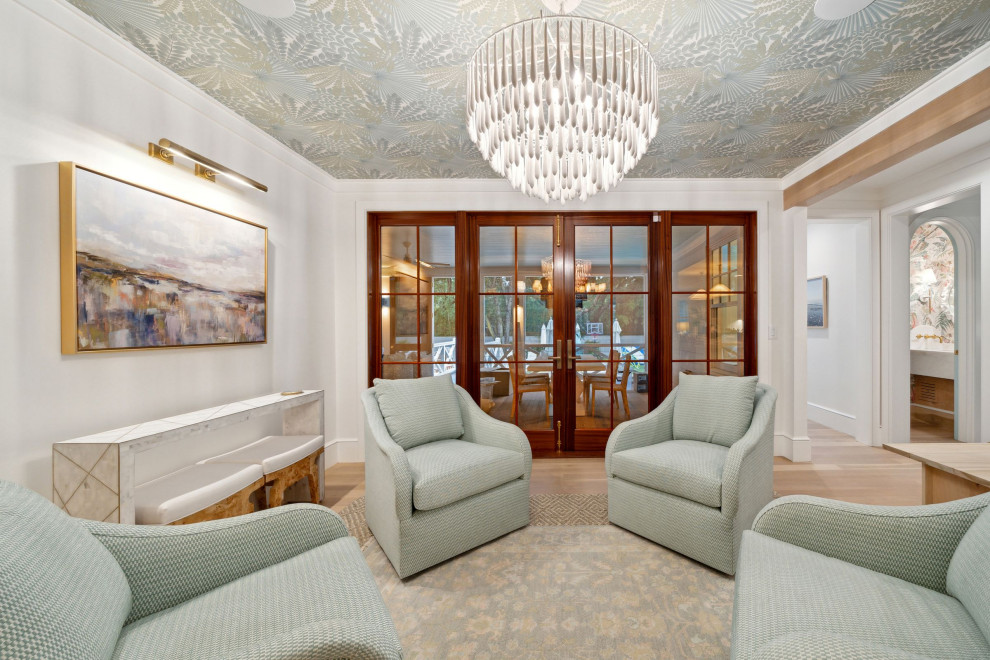 Maritimes Wohnzimmer mit weißer Wandfarbe, hellem Holzboden und Tapetendecke in Charleston