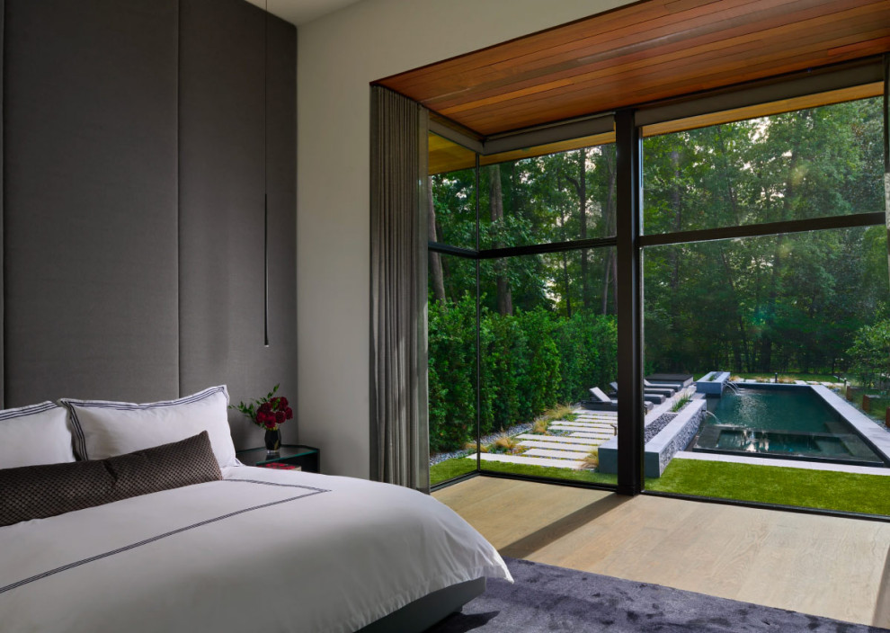 Photo of a modern master bedroom in Atlanta with white walls and light hardwood floors.