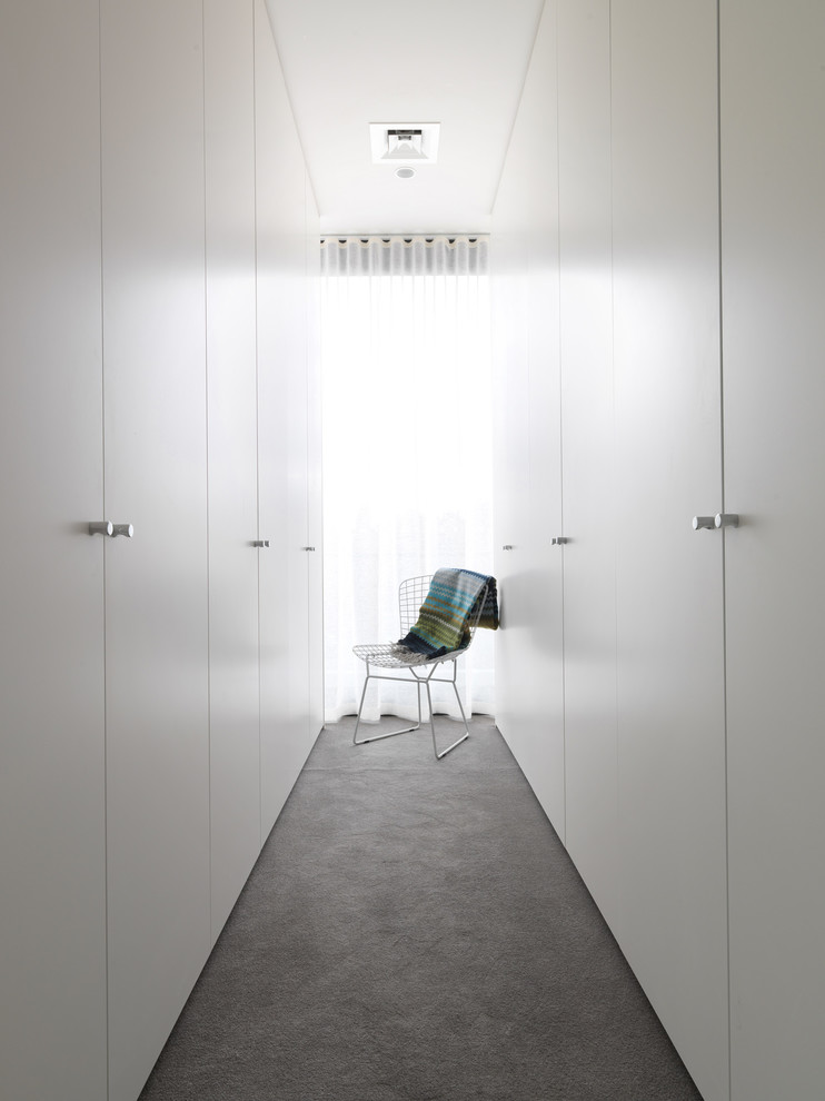 Photo of a contemporary gender-neutral storage and wardrobe in Melbourne with carpet.