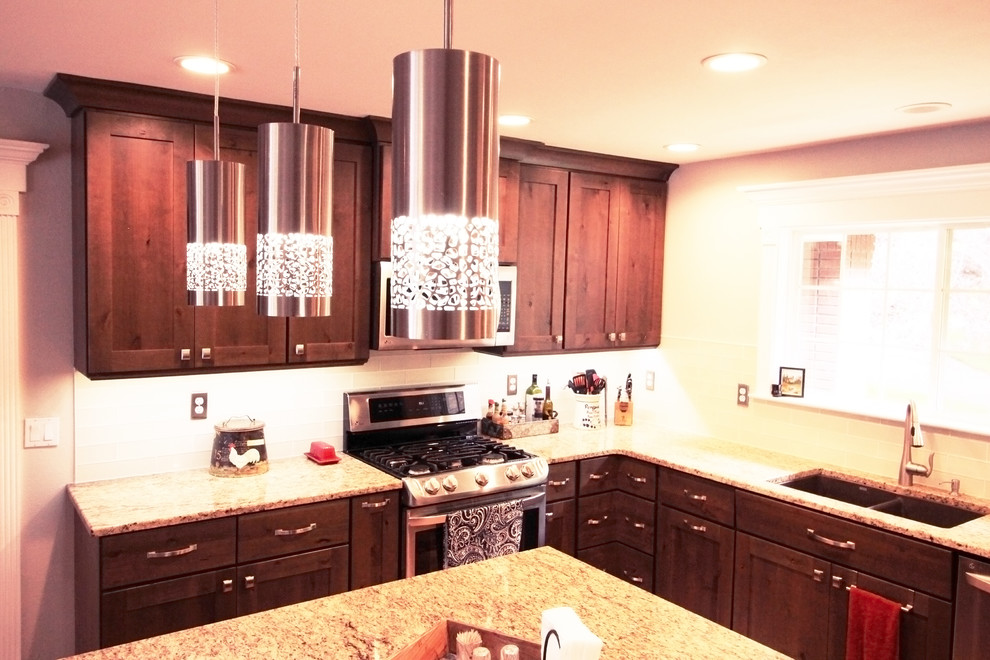 Example of a large mountain style u-shaped light wood floor and brown floor open concept kitchen design in Boise with an undermount sink, shaker cabinets, brown cabinets, granite countertops, white backsplash, glass tile backsplash, stainless steel appliances and an island