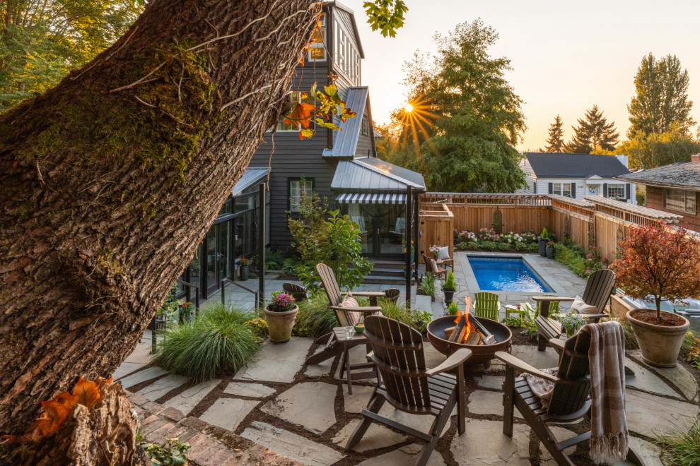 Patio - huge eclectic backyard stone patio idea in Seattle with a fire pit and no cover