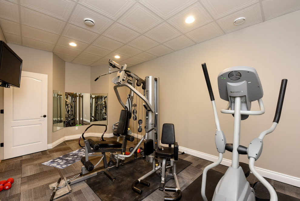 Photo of an expansive contemporary home gym in Chicago with beige walls, carpet and beige floor.