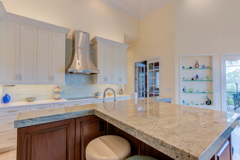 Inspiration for a large transitional single-wall enclosed kitchen remodel with an undermount sink, flat-panel cabinets, white cabinets, quartz countertops, blue backsplash, stone tile backsplash, stainless steel appliances and an island