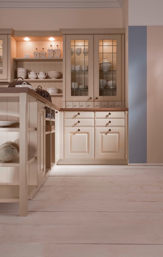 Inspiration for a mid-sized transitional l-shaped eat-in kitchen in New York with a drop-in sink, raised-panel cabinets, beige cabinets, wood benchtops, beige splashback, stainless steel appliances, painted wood floors and a peninsula.