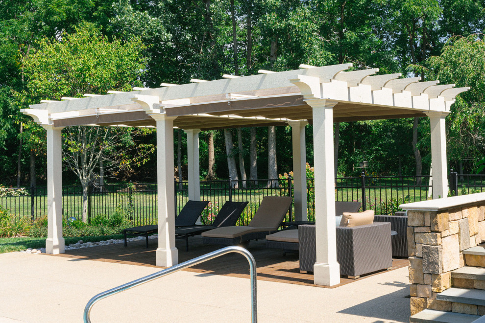Elegant backyard ground level privacy and metal railing deck photo in Columbus with a pergola