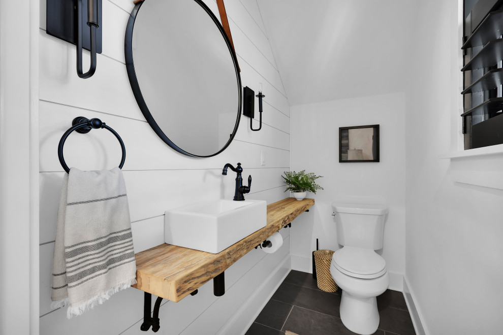 Design ideas for a small farmhouse cloakroom in Jacksonville with light wood cabinets, a one-piece toilet, white walls, ceramic flooring, wooden worktops, grey floors, brown worktops and a floating vanity unit.