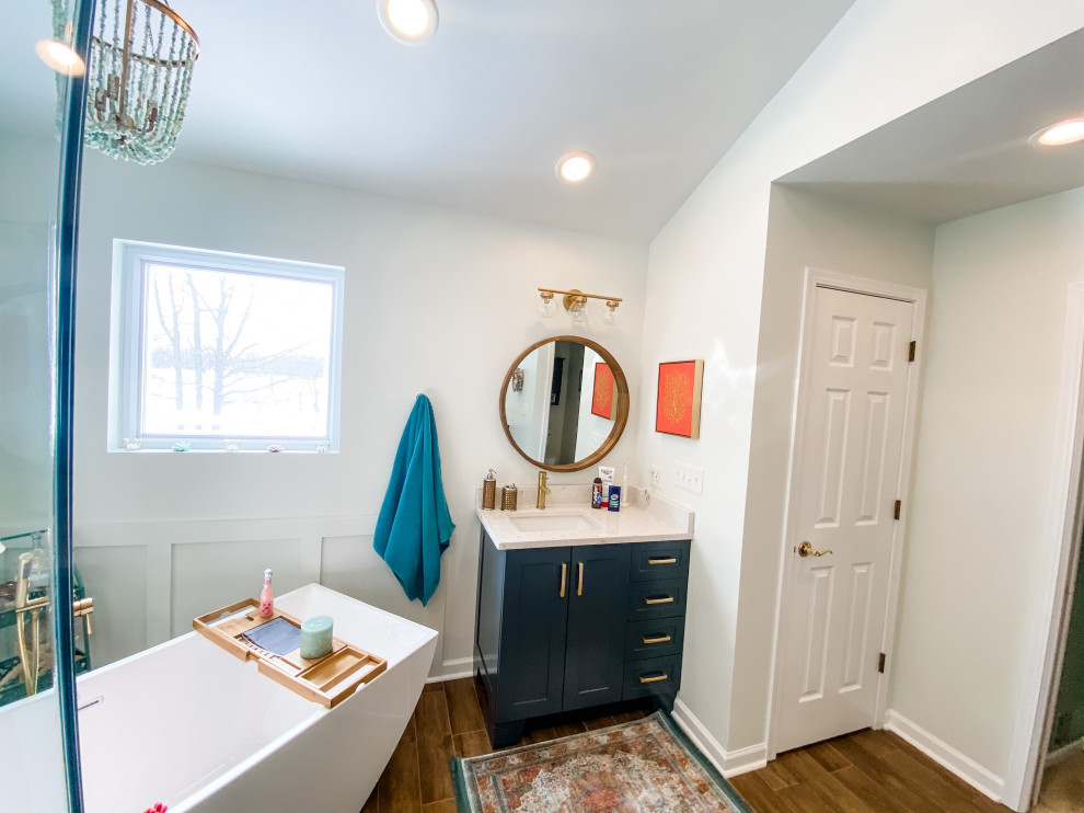 Large trendy master porcelain tile, brown floor, single-sink, vaulted ceiling and wainscoting bathroom photo in Chicago with shaker cabinets, blue cabinets, white walls, an undermount sink, quartz countertops, a hinged shower door, beige countertops and a built-in vanity