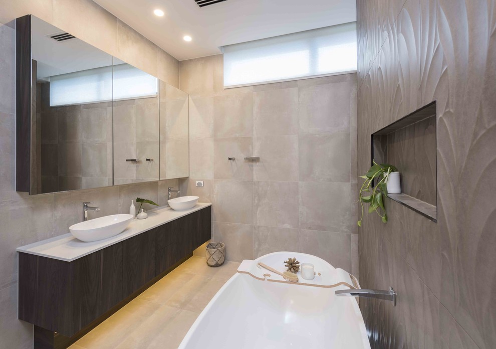 This is an example of a contemporary master wet room bathroom in Melbourne with flat-panel cabinets, dark wood cabinets, a freestanding tub, brown tile, porcelain tile, grey walls, porcelain floors, a vessel sink, engineered quartz benchtops, an open shower and white benchtops.