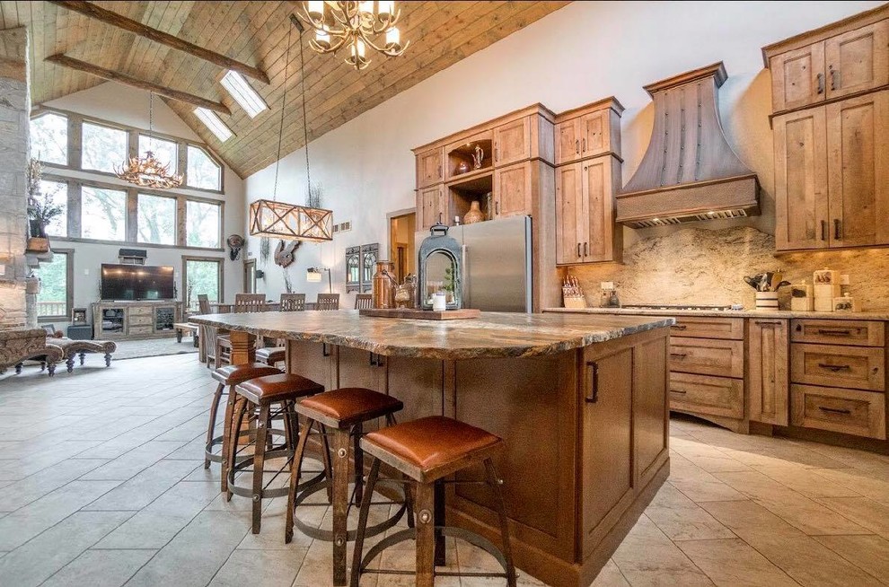 Inspiration for a large rustic l-shaped eat-in kitchen remodel in Chicago with a farmhouse sink, granite countertops, beige backsplash, stone slab backsplash, stainless steel appliances, an island and beige countertops