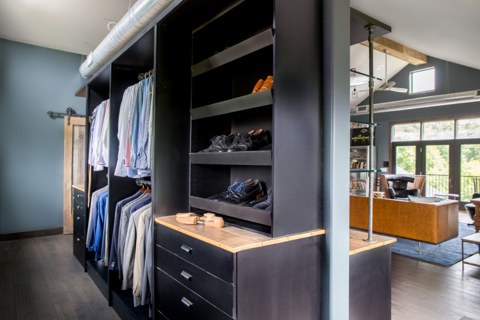 Photo of a mid-sized modern men's dressing room in Cedar Rapids with flat-panel cabinets, black cabinets, dark hardwood floors, brown floor and vaulted.