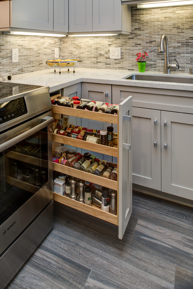 Example of a mid-sized transitional u-shaped dark wood floor kitchen pantry design in San Francisco with an undermount sink, shaker cabinets, gray cabinets, quartz countertops, stainless steel appliances, a peninsula, multicolored backsplash and mosaic tile backsplash