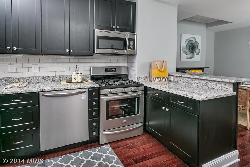 Eat-in kitchen - small modern single-wall dark wood floor eat-in kitchen idea in Baltimore with an undermount sink, shaker cabinets, black cabinets, granite countertops, white backsplash, ceramic backsplash and stainless steel appliances