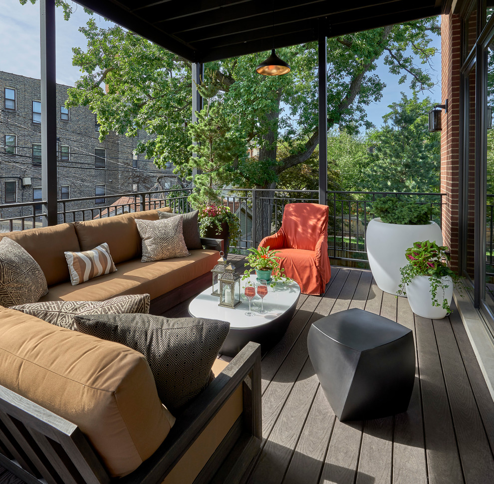 Photo of a mid-sized contemporary backyard deck in Chicago with a roof extension.