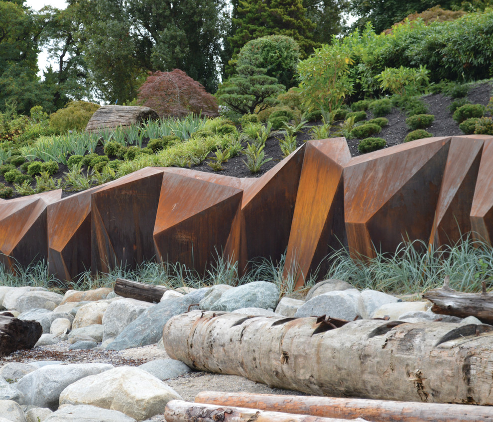 Design ideas for a large contemporary full sun hillside retaining wall landscape in Vancouver.