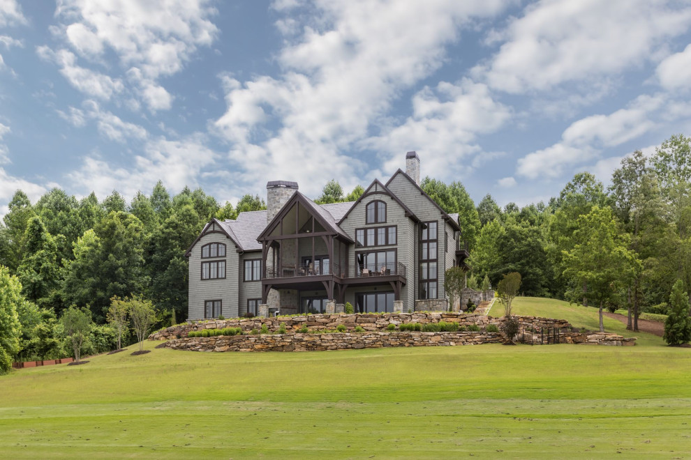 Inspiration for a large transitional gray three-story stone and shingle gable roof remodel with a tile roof and a gray roof