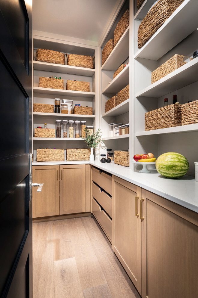 This is an example of a mid-sized modern galley kitchen pantry in Other with a farmhouse sink, light wood cabinets, quartz benchtops, white splashback, marble splashback, stainless steel appliances, light hardwood floors, no island, brown floor, white benchtop and vaulted.