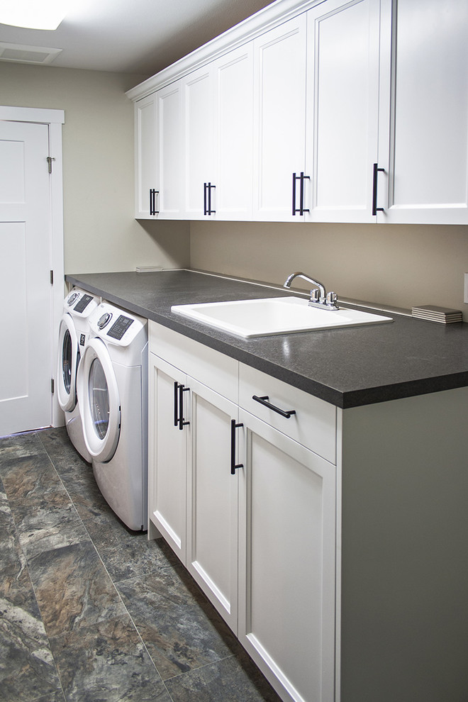 Design ideas for a large arts and crafts galley utility room in Seattle with a drop-in sink, recessed-panel cabinets, white cabinets, laminate benchtops, grey walls, linoleum floors, a side-by-side washer and dryer and grey benchtop.