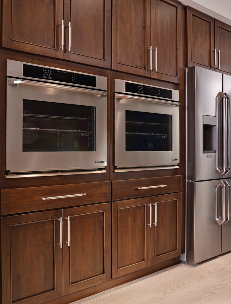 Example of a large transitional single-wall light wood floor open concept kitchen design with an island, an undermount sink, recessed-panel cabinets, medium tone wood cabinets and stainless steel appliances