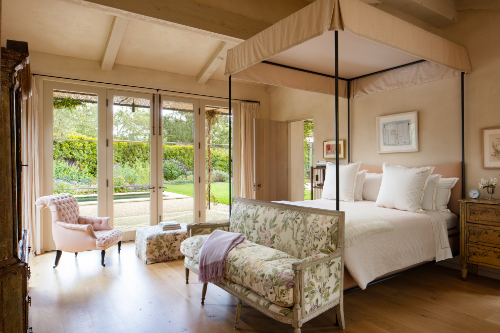 Mittelgroßes Mediterranes Hauptschlafzimmer ohne Kamin mit beiger Wandfarbe, braunem Holzboden, braunem Boden, freigelegten Dachbalken und gewölbter Decke in Santa Barbara