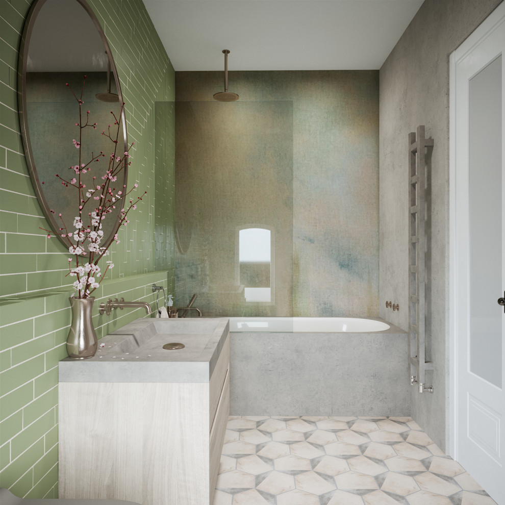 Photo of a mid-sized contemporary master bathroom in London with flat-panel cabinets, light wood cabinets, a drop-in tub, a shower/bathtub combo, a wall-mount toilet, green tile, ceramic tile, grey walls, ceramic floors, a drop-in sink, concrete benchtops, multi-coloured floor, a hinged shower door, grey benchtops, a single vanity and a floating vanity.