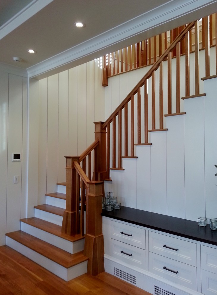 This is an example of a mid-sized traditional wood l-shaped staircase in Boston with painted wood risers and wood railing.