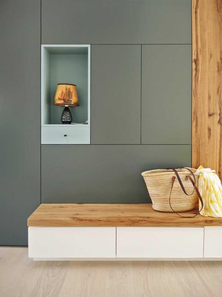 Skandinavischer Eingang mit Stauraum, grauer Wandfarbe und hellem Holzboden in Berlin