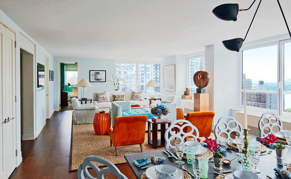Inspiration for an expansive eclectic open concept living room in New York with blue walls, medium hardwood floors, no fireplace, a wall-mounted tv and brown floor.