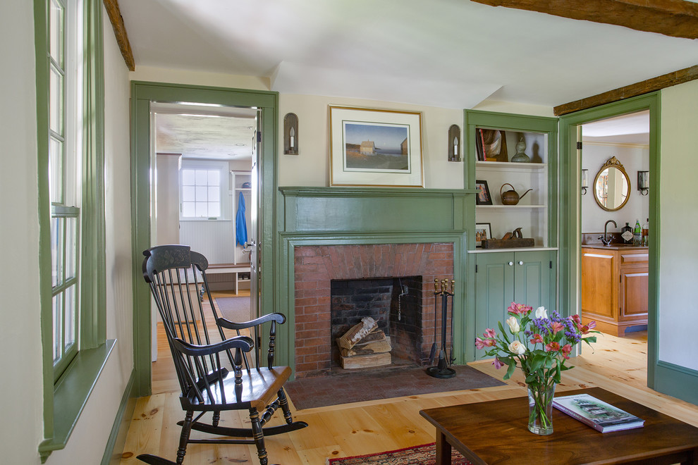 Living room library - small country enclosed light wood floor living room library idea in Boston with white walls, a standard fireplace, no tv and a brick fireplace